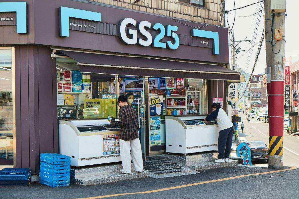 韓国のコンビニGS25の店舗外観。ガラス張りの明るい店内に人が出入りする様子。韓国コンビニの代表的なチェーンの一つ。